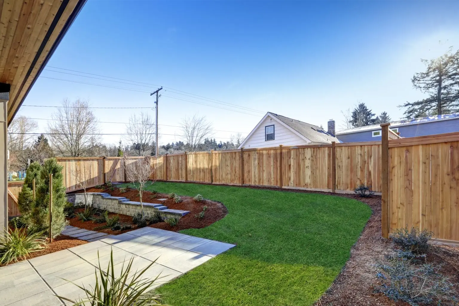 Sloped backyard surrounded by wooden fence Luxury New construction